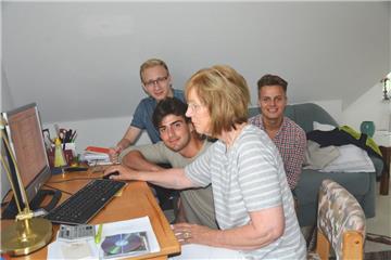 Nils Frank (von links) Malik Bransi und Lukas Bornschier (rechts) helfen Gerda Müller bei ihren Computerproblemen.