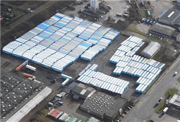 Nur aus der Luft sind die gewaltigen Dimensionen voll sichtbar: Gegenüber der Elan-Tankstelle (unten rechts) im Fischereihafen in Bremerhaven hat Amazon über 400 seiner blitzblauen Koffer-Auflieger abgestellt.