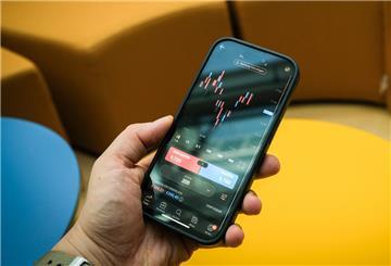 Ein Mann haelt am 28.08.2024 in Berlin ein Smartphone in der Hand auf dem Aktienkurse zu sehen sind (gestellte Szene). NVIDIA, TSMC, Alphabet, CrowdStrike und CRISPR zählen laut finanzen.net zu den aussichtsreichsten Aktien für langfristige Anleger. Sie profitieren von starken Zukunftstrends wie KI, Chips und Gentechnik.