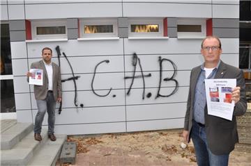 Ob Fenster oder Fassaden: Der unbekannte Graffiti-Sprayer hat allein an sieben Wänden der Hauptstelle der Oste-Hamme-Schule seine Spuren hinterlassen. Bürgermeister Axel Renken (rechts) und Geschäftsbereichsleiter Marcel van der Pütten hoffen, dass mit einer Belohnung der Täter ermittelt werden kann. Die Abkürzung ACAB steht für die englischsprachige Version der Parole „Alle Polizisten sind Bastarde“.