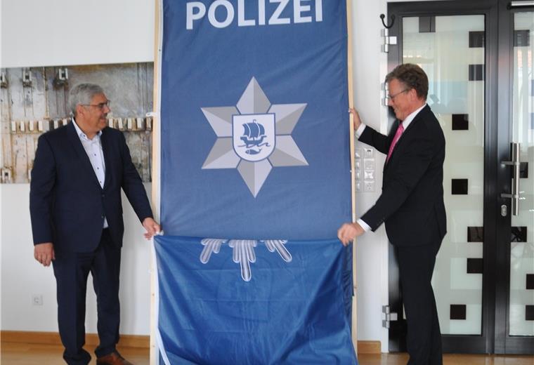 Ein neuer Sheriffstern für die Polizei Oberbürgermeister Melf Grantz (links) und Harry Götze, der Direktor der Ortspolizeibehörde, bei der Enthüllung des neuen Logos. Der Polizei-Stern wirkt nun moderner.