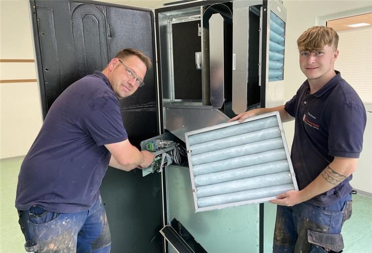 Frische Luft für Butjadinger Grundschule und Kitas Oliver Buchholz (links) hat die Klappe geöffnet, hinter der die Steuerung der Anlage sitzt. Sein Kollege Tom Brockmann präsentiert den Filter, der bei Inspektionen gereinigt oder ausgetauscht werden muss.
