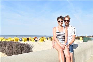 Oliver und Madlen aus Schleswig-Holstein flittern bei herrlichem Sonnenschein am Duhner Strand. 