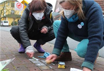 „Omas gegen Rechts“ bei der Arbeit: Marie Pfeiffer (links) und Andrea Türk beim Reinigen der Stolpersteine für Angehörige der Familie Brumsack in der Beverstedter Poststraße.