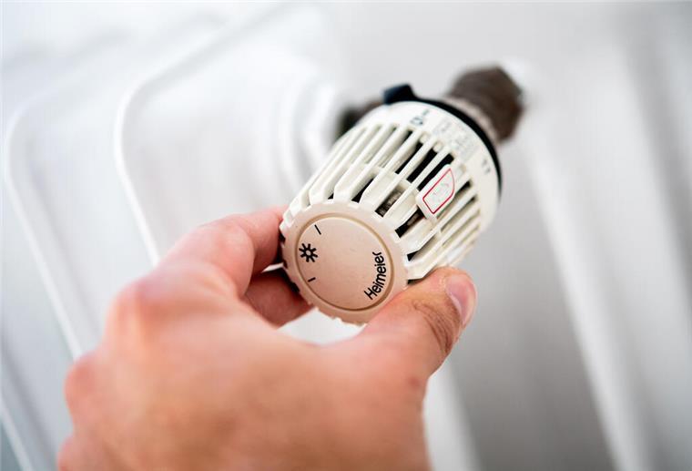 Fernwärme: So können Bremerhavener die Verfügbarkeit prüfen Ein Mann dreht in einer Wohnung am Thermostat einer Heizung.