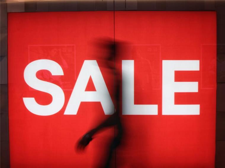 Sparstrategien beim Online-Shopping: So lässt sich Geld einsparen Großes rotes Sale-Schild mit weißer Schrift.