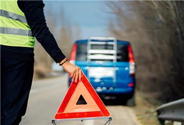 Warndreieck wird bei einer Autopanne aufgestellt. Bei einer Autopanne ist es wichtig, einige Tipps zu beachten. 