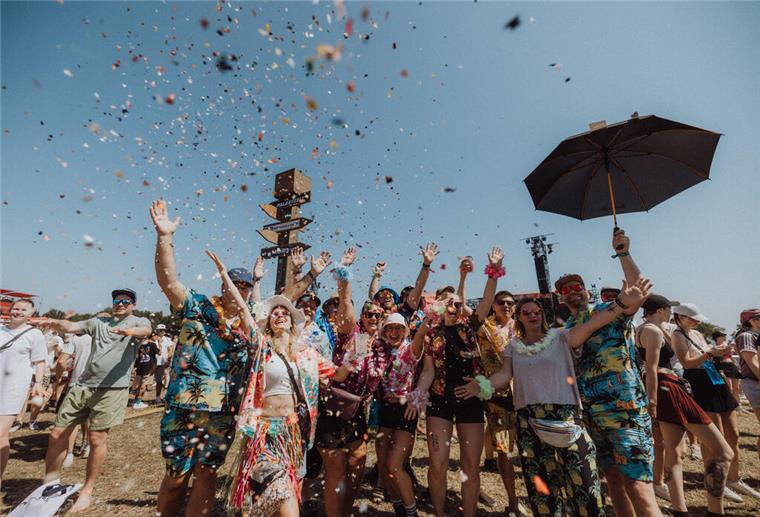 Gewinnt Merch-Gutschein vom Deichbrand für das lustigste Festivalfoto Menschen unter Konfettiregen