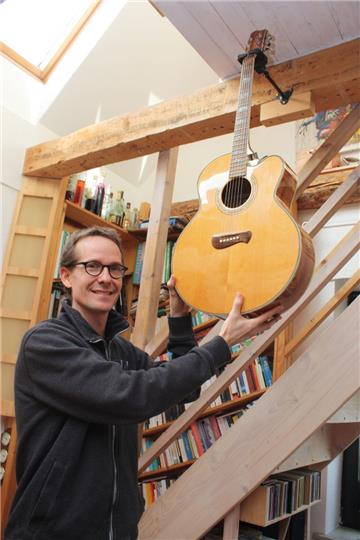Pascal Gentners Gitarre hängt an der Decke. Das offene Wohnzimmer ist der Lebensmittelpunkt des neuen Musikschulleiters.  Foto Gehrke
