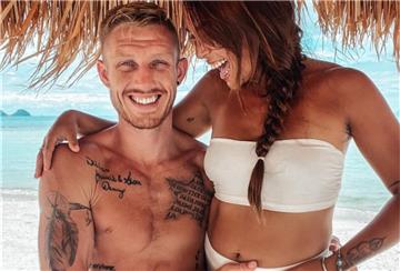 Mann und Frau unter einem Sonnenschirm auf Insel, Meer im Hintergrund