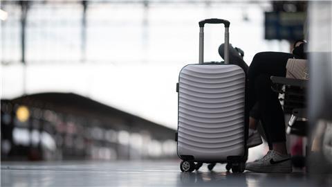Passagiere warten am Bahnhof auf ihren Zug.