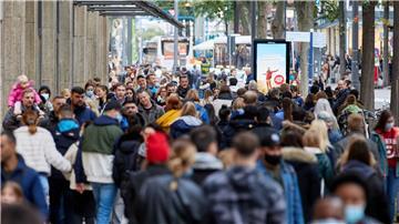 Passanten gehen über eine Einkaufsstraße.