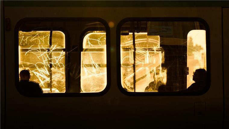 Fahrgastverband fordert schnelleren ÖPNV-Ausbau Passanten sitzen am frühen Morgen im Gegenlicht der aufgehenden Sonne in einer Straßenbahn.