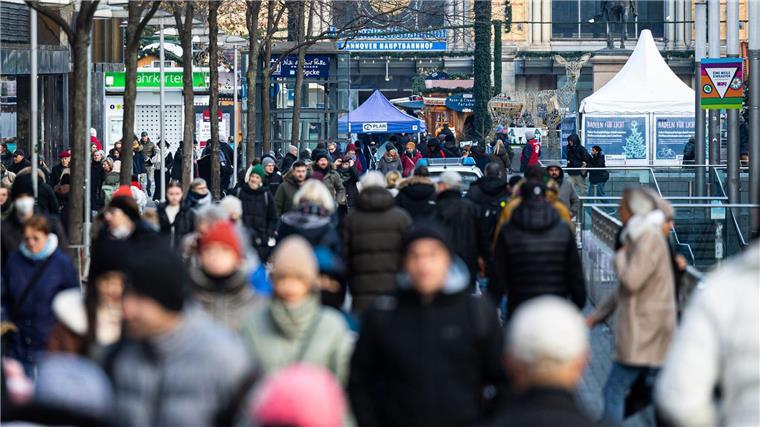 Passantinnen und Passanten gehen in der Fußgängerzone in der Innenstadt.
