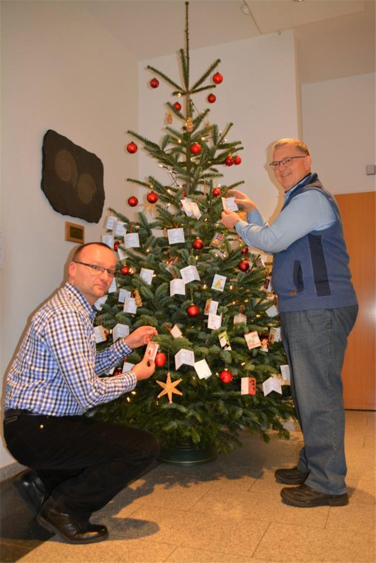 Aktion: Weihnachtsgeschenke für arme Kinder Pastor Dirk Glanert (links) und Johann Haack hängen die letzten Wunschkärtchen an die Zweige des Weihnachtswunschbaumes.