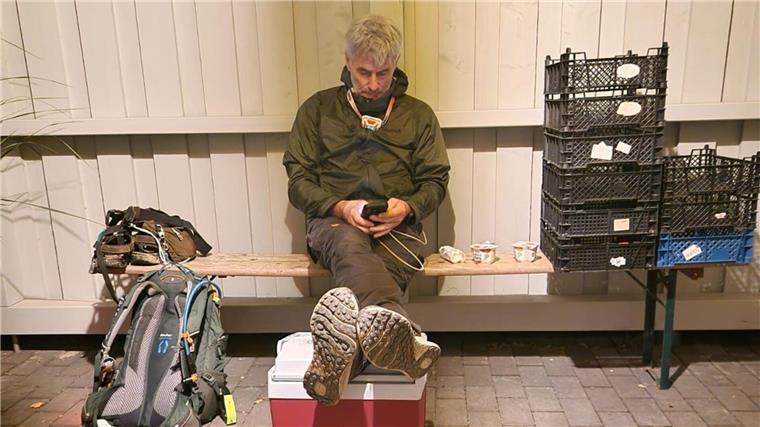 Geestlandumwanderung geschafft: 132 Kilometer in 31 Stunden Ein Mann sitzt auf einer Bank neben einem Rucksack und Körben.