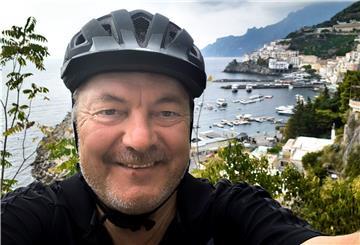 Mann mit Fahrradhelm an Küste