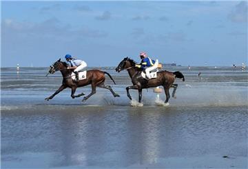 Auf dem Meeresboden vor Cuxhaven reiten Teilnehmer durchs Watt.