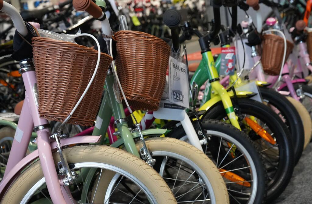 Aufgereihte Kinderfahrräder in mehreren Größen.