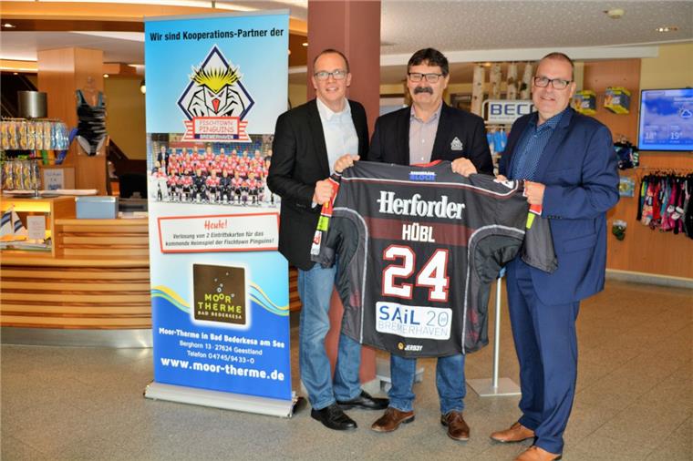 Pinguins-Teammanager Alfred Prey (Mitte) hat zum Gewinnspiel-Auftakt ein Original-Spielertrikot mitgebracht für die Moor-Therme mitgebracht.