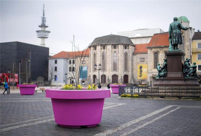 Ein pinkfarbener Kübel ist auf einem öffentlichen Platz zu sehen. 
