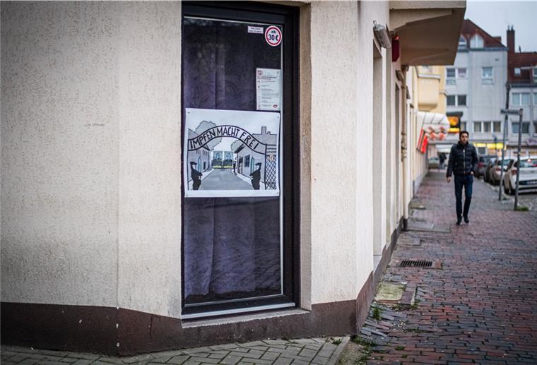 Eine Plakat klebt auf einer Fensterscheibe.