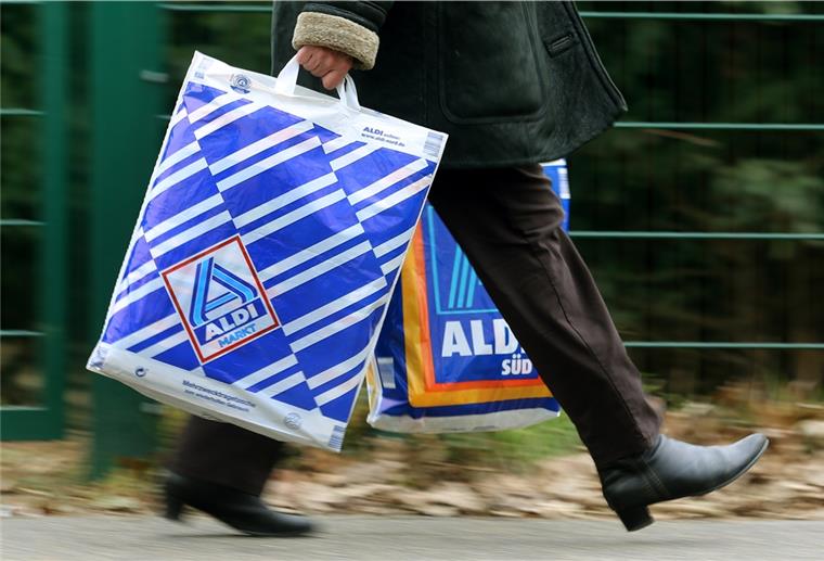 Bundestag beschließt Plastiktüten-Verbot Die Kundin einer Aldi-Filiale trägt am 26.03.2013 in Essen (Nordrhein-Westfalen) in einer Einkaufstüte von Aldi-Nord und einer von Aldi-Süd ihre Einkäufe.