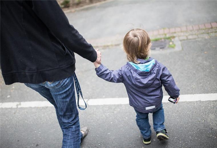 Eine Mutter hält ihren Sohn an der Hand. Alleinerziehende und ihre Kinder sind einer Studie zufolge in deutlich überproportionalem Ausmaß von finanzieller Armut bedroht.