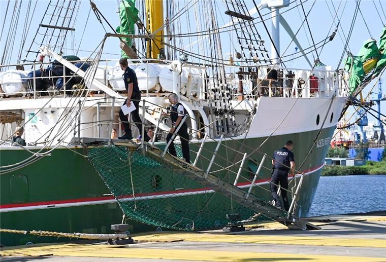 Polizeibeamte gehen im Fischereihafen an Bord der "Alex II".