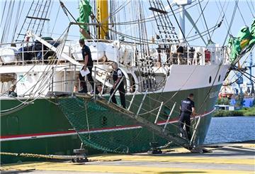 Polizeibeamte gehen im Fischereihafen an Bord der "Alex II".
