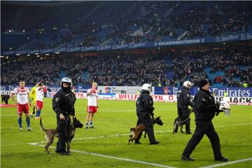 Polizeikräfte mit Hunden und Security-Mitarbeiter sichern das Spielfeld nach dem Abpfiff.