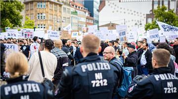 Polizisten beobachten zahlreiche Demonstranten.