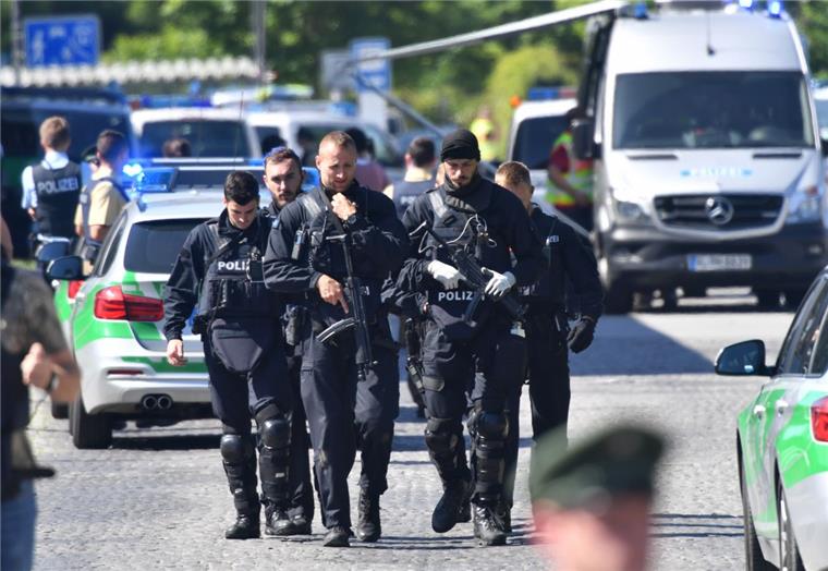 Polizisten haben am S-Bahnhof in Unterföhring die Gegend nach Schüssen auf eine Polizistin abgesichert.  