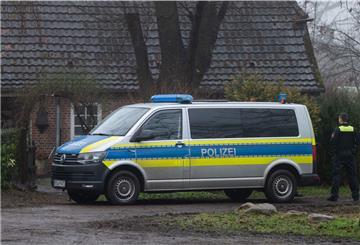 Polizisten stehen vor einem Haus, in dem am Vorabend zwei Tote aufgefunden wurden