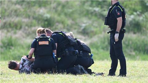 Polizisten stellen den mutmaßlichen Täter.