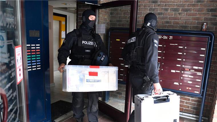 Bekämpfung von Clankriminalität Polizisten tragen Kisten aus einem Gebäude, in dem die Polizei vorher eine Razzia gegen Clankriminalität durchgeführt hat.