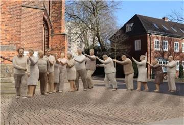 Lebensgroße Figuren in einer Stadt vor einer Kirche, Polonaise.