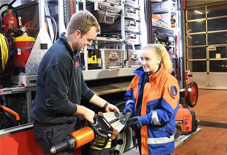 Praxistipps vom Profi: Christian Hildebrandt, Brandmeister und Notfallsanitäter bei der Bremerhavener Berufsfeuerwehr, erläutert Lilian Bange, stellvertretende Jugendsprecherin der Jugendfeuerwehr Lehe, einen hydraulischen Spreizer zur Befreiung von Unfallopfern.