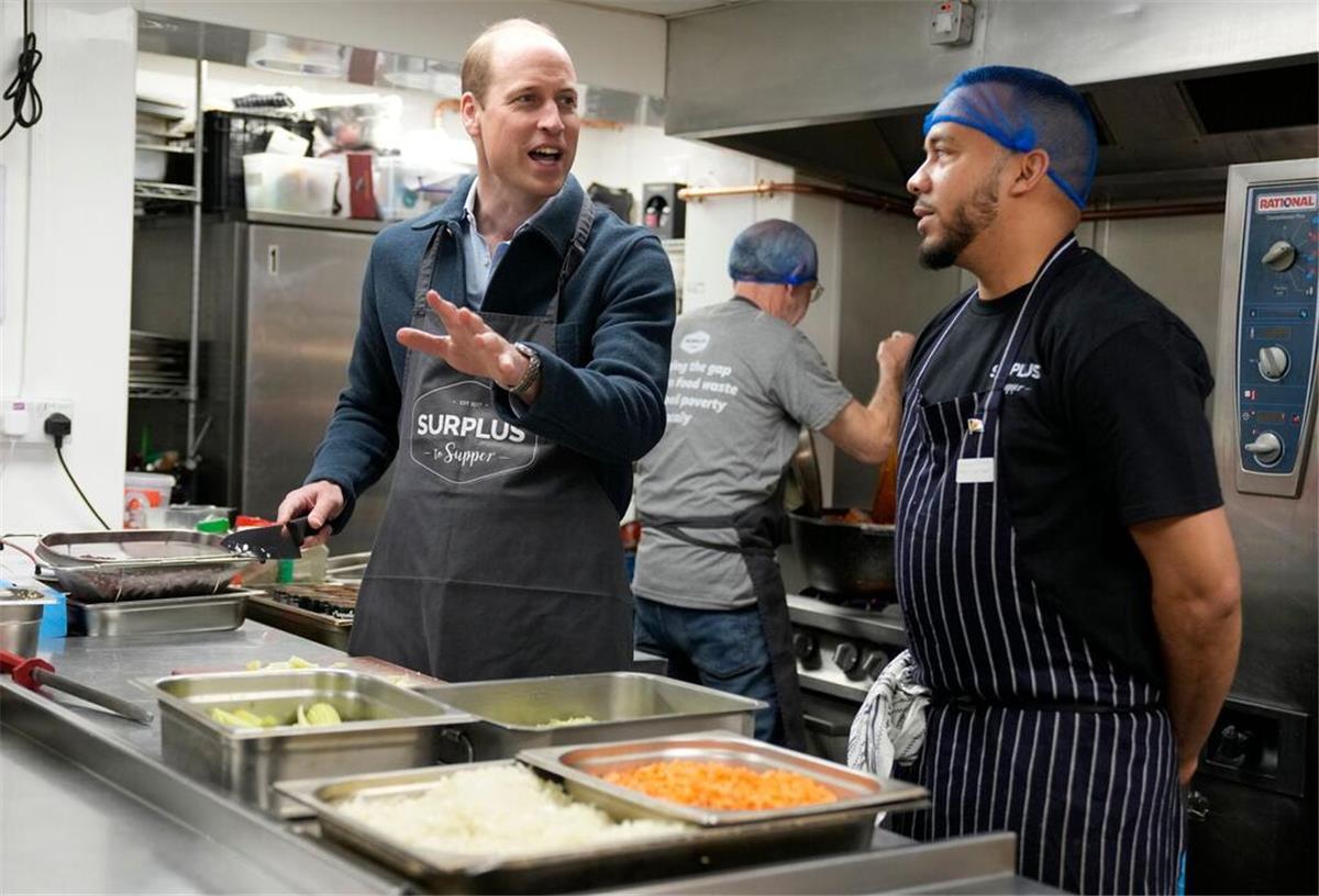 Prinz William (l) hilft dem Chefkoch Mario Confait bei der Herstellung von Bolognese-Sauce.
