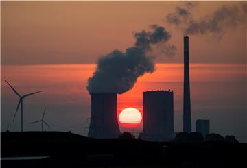 Rauch steigt aus dem Schornstein eines Kraftwerks in die Höhe - und das bei einem Sonnenuntergang.