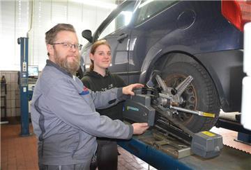 Pascal Siems und Azubi Patrizia Koch schrauben an einem Auto.