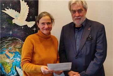 Eine Frau und ein Mann stehen vor einem Wandbild