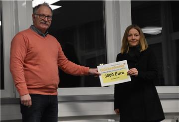 Projektverantwortlicher bei Premium Aerotec, Ralf Hesse übergibt Melanie Büsing, Erzieherin in der Kinderkrippe De lütten Trolle den Scheck in Höhe von 3.000 für die Anschaffung eines neuen Klettergerüsts.