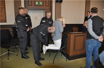 Prozessauftakt: Wachleute führen einen der Angeklagten in den Gerichtssaal.