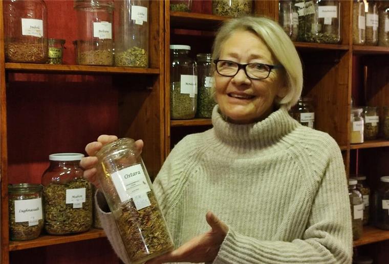 Frau zeigt Glas mit Kräutern