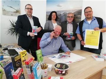 Rainer Eberl sitzt im Mobilitätspunkt am Telefon. Über das neue Informationsangebot in Bad Bederkesa freuen sich (von links) Geestlands Bürgermeister Thorsten Krüger, Gabi Kasten vom Landkreis Cuxhaven, Geestlands Erster Stadtrat Jürgen Zehm und Michael Brümmer, Inhaber von Taxenruf Geestland.