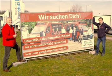 Ralf Bierhorst (links) und Andreas Bergelt montieren ein Werbebanner an der B 71. 