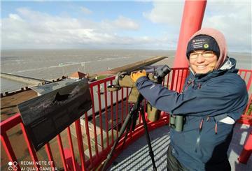 Rangerin Annelie Hedden mit einem Spektiv am Wattenmeer.