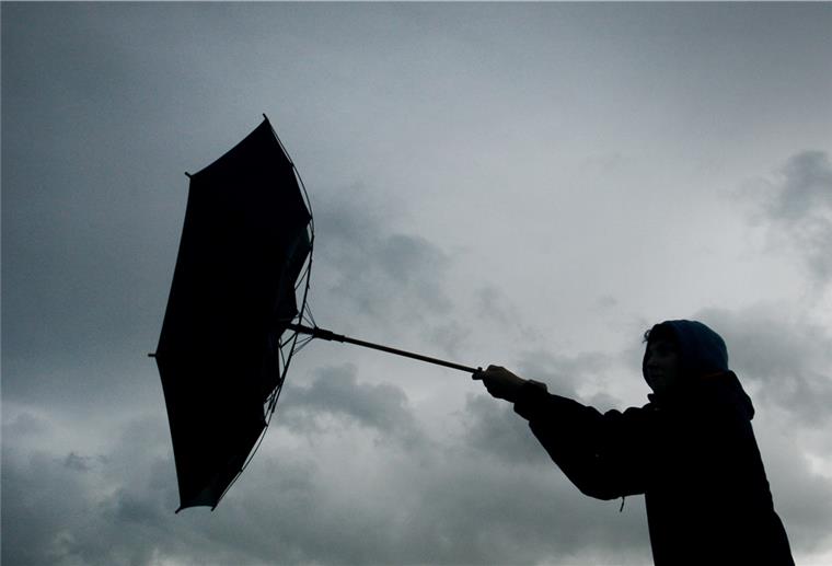 Kühle Temperaturen und Regen im Norden Von einer Windböe erfasst wird am 13.07.2011 der Regenschirm eines Spaziergängers bei Marktoberdorf (Schwaben).
