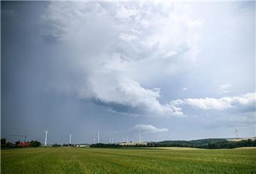 Eine Regenfront mit dunklen Wolken hinter einem Gerstenfeld. (Symbolbild) Foto: Marius Bulling/dpa